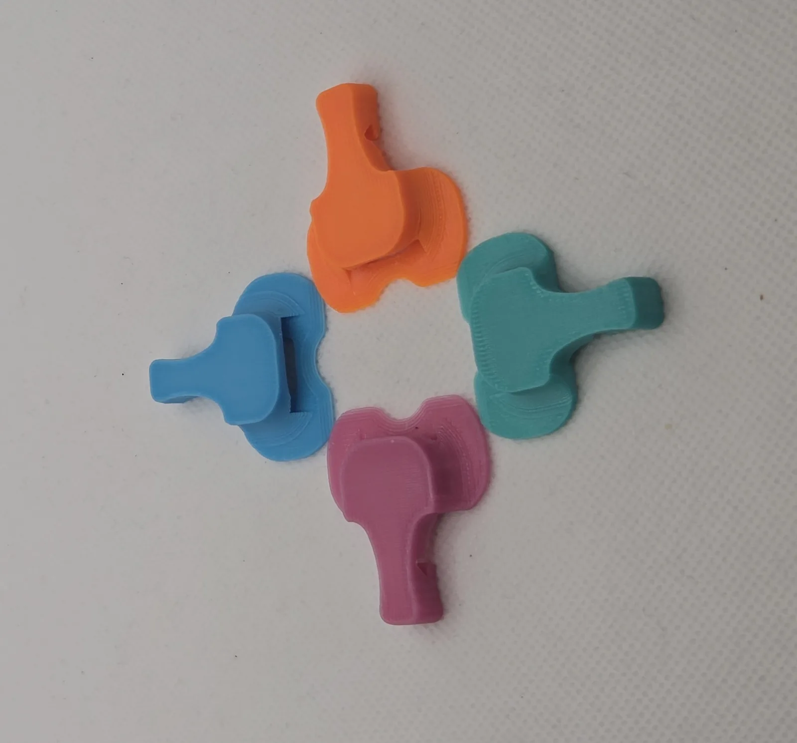 Four Elephant Covers in orange, blue, teal and pink, photographed from directly above on a pale ground.