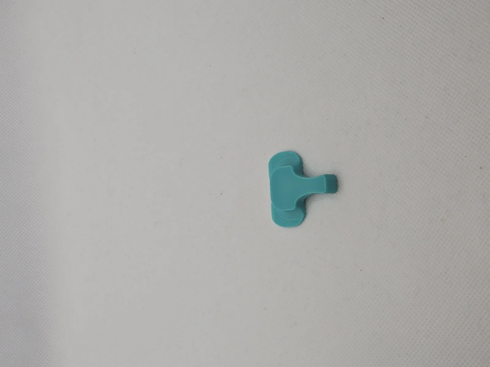 A single teal Elephant Cover alone on a pale ground, showing the trunk and the slot.