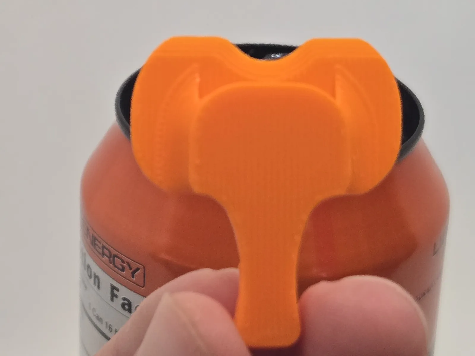The orange cover spun around so its body sits over the can's opening.