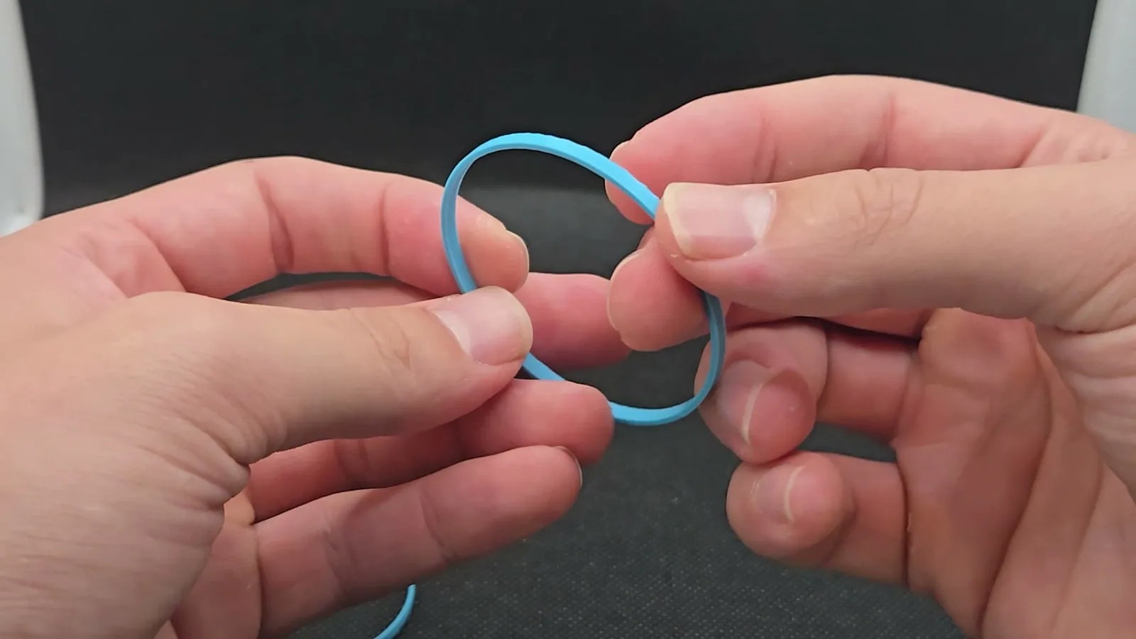 Hands holding an unperforated printed ring, an earlier variant of the shade.