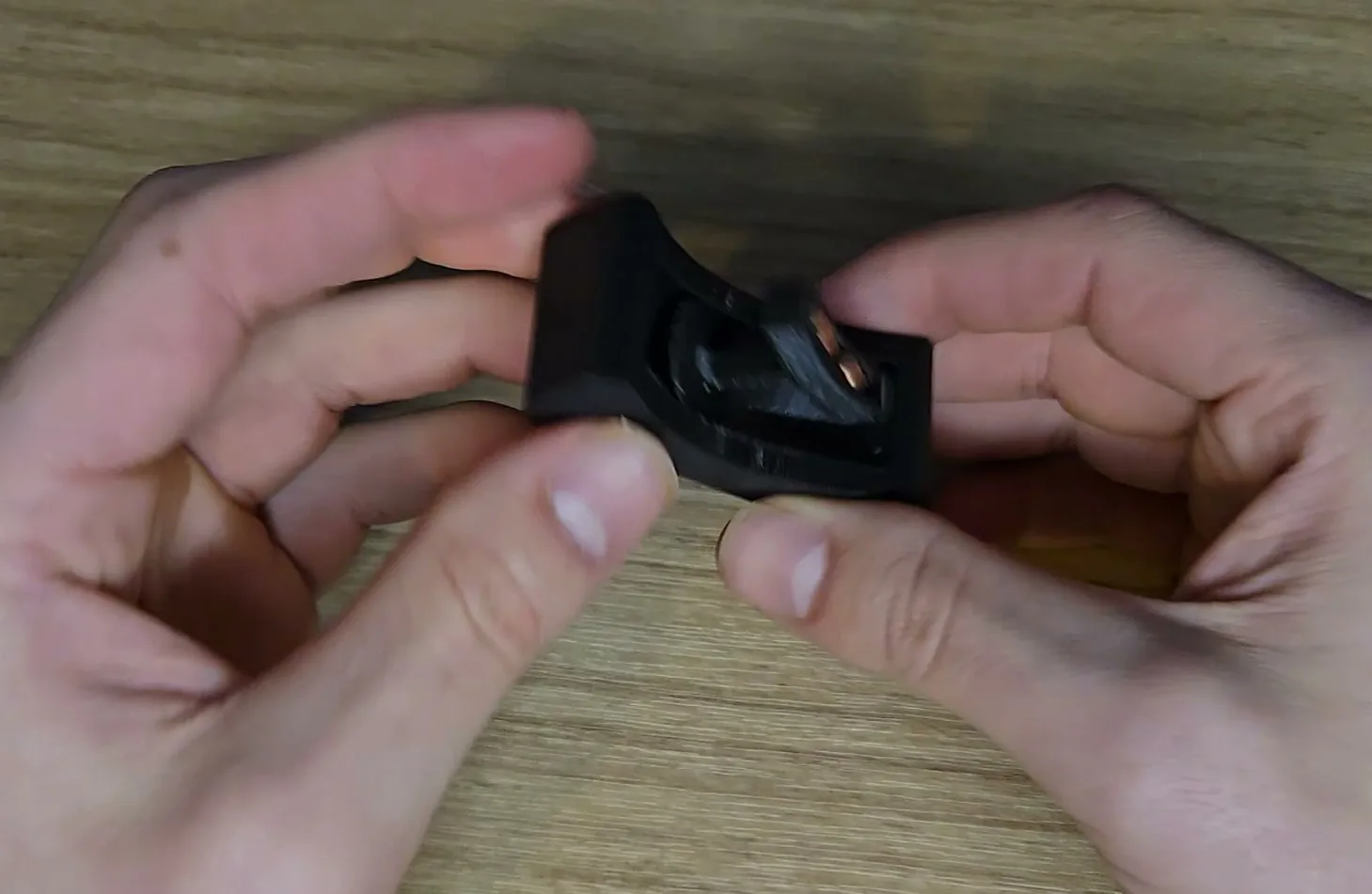 The finished part printed in black, held in two hands, the handle standing in its curved groove.